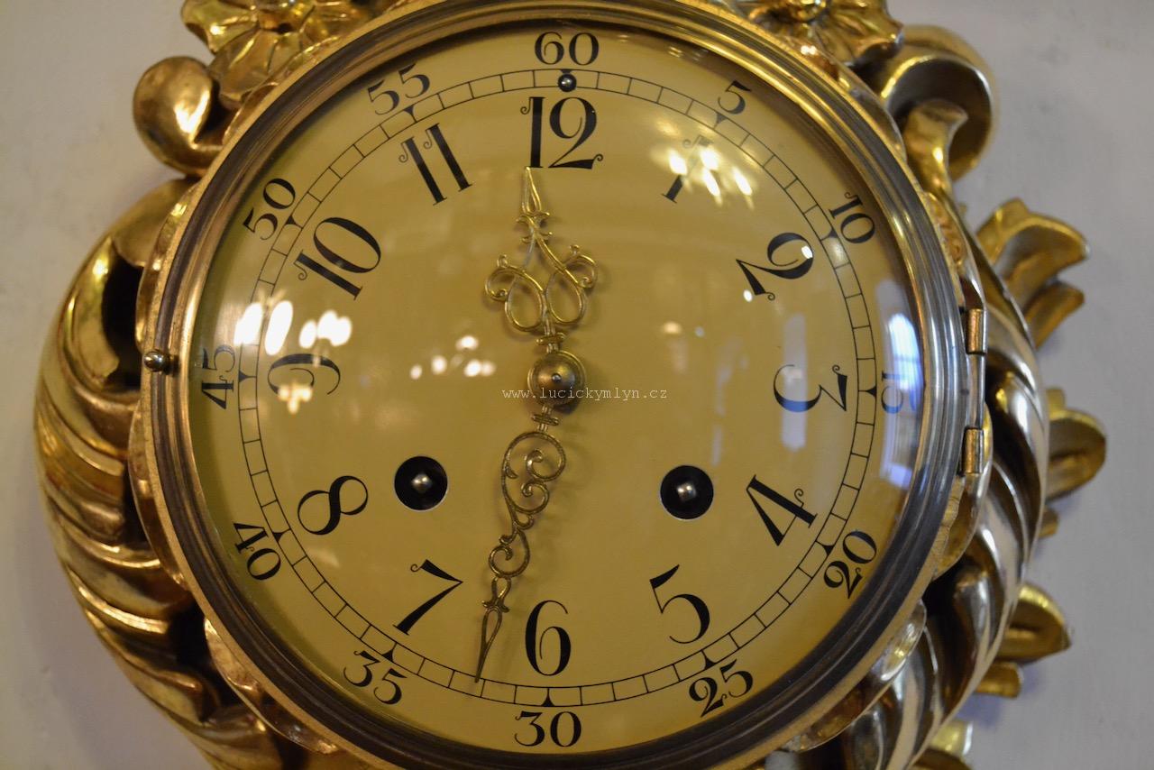 Bohatě řezané a zlacené nástěnné hodiny v rokokovém stylu