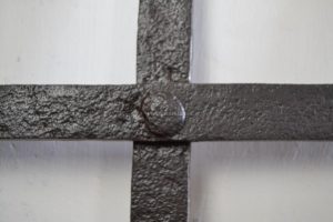 Velmi pevná okenní mříž z ručně vykované a pevně snýtované pásoviny