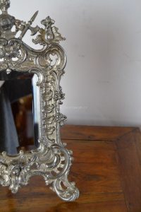 Bohatě zdobené stolní zrcátko s neobarokním rámečkem z blanenské umělecké litiny
