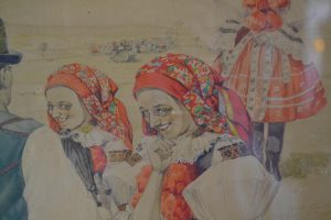Obraz - Tři dívčí Vlčnovjanky, vlevo sedící Uherská Ostrovjanka a šuhaj Velečan