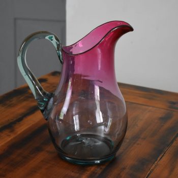 Hezky tvarovaný a barevně tónovaný starožitný džbán z foukaného skla