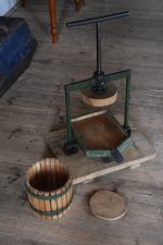 Historický ruční lis na ovoce a révu s pevnou ocelovou konstrukcí, jež je k dřevěné podstavě připevněna šrouby