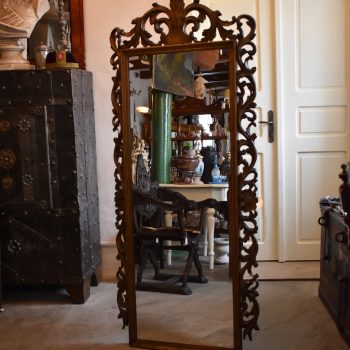 Větší starožitné zrcadlo s bohatě řezaným a temně zlaceným rámem
