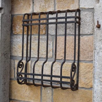 Menší starožitná ocelová prvorepubliková okenní mříž