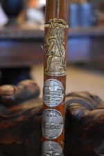 Starožitná turistická hůl téměř celá pokrytá štítky z cest