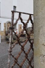 Větší starožitná ozdobně ztvárněná a pevně rámovaná okenní mříž