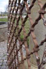 Větší starožitná ozdobně ztvárněná a pevně rámovaná okenní mříž