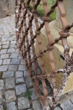 Větší starožitná ozdobně ztvárněná a pevně rámovaná okenní mříž