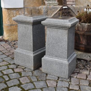 Pár robustních starožitných hranolových podstavců ze šedé žuly s profilovanou hlavicí