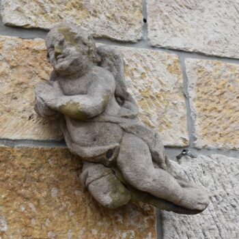 Barokní pískovcový andílek putti z portálu broumovského kláštera.