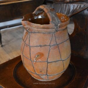 Starožitný barokní koutní hrnec z hnědé glazované keramiky s drátěným opletením.
