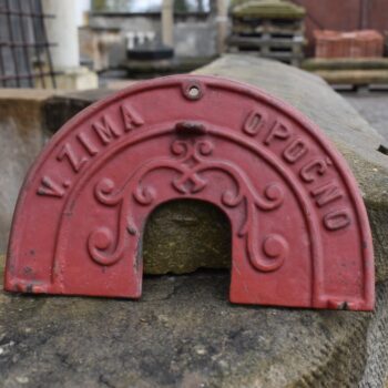 Litinový štítek z historické mlátičky výrobce V. ZIMA OPOČNO se secesním ornamentem.