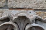 Secesní fasádní štukatérský reliéf s hlavou ženy a florálně ornamentálním dekorem.