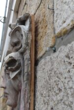 Secesní fasádní štukatérský reliéf s hlavou ženy a florálně ornamentálním dekorem.