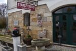 Secesní fasádní štukatérský reliéf s hlavou ženy a florálně ornamentálním dekorem.