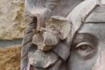 Secesní fasádní štukatérský reliéf s hlavou ženy a florálně ornamentálním dekorem.