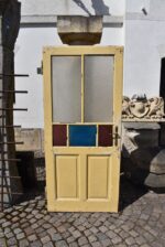 Starožitné rámové dveře se secesními kazetami a barevnými prosklenými poli z počátku 20. století.