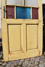 Starožitné rámové dveře se secesními kazetami a barevnými prosklenými poli z počátku 20. století.