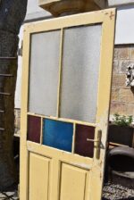 Starožitné rámové dveře se secesními kazetami a barevnými prosklenými poli z počátku 20. století.