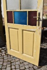 Starožitné rámové dveře se secesními kazetami a barevnými prosklenými poli z počátku 20. století.