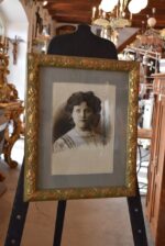Dobová ateliérová fotografie mladé dámy v secesním zlaceném rámu z roku 1910