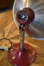 Prvorepubliková industriální stolní lampa s hliníkovým stínidlem a bakelitovou zástrčkou.