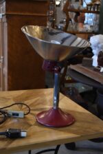 Prvorepubliková industriální stolní lampa s hliníkovým stínidlem a bakelitovou zástrčkou.