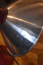 Prvorepubliková industriální stolní lampa s hliníkovým stínidlem a bakelitovou zástrčkou.