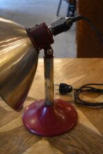 Prvorepubliková industriální stolní lampa s hliníkovým stínidlem a bakelitovou zástrčkou.