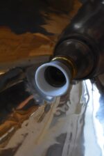 Prvorepubliková industriální stolní lampa s hliníkovým stínidlem a bakelitovou zástrčkou.