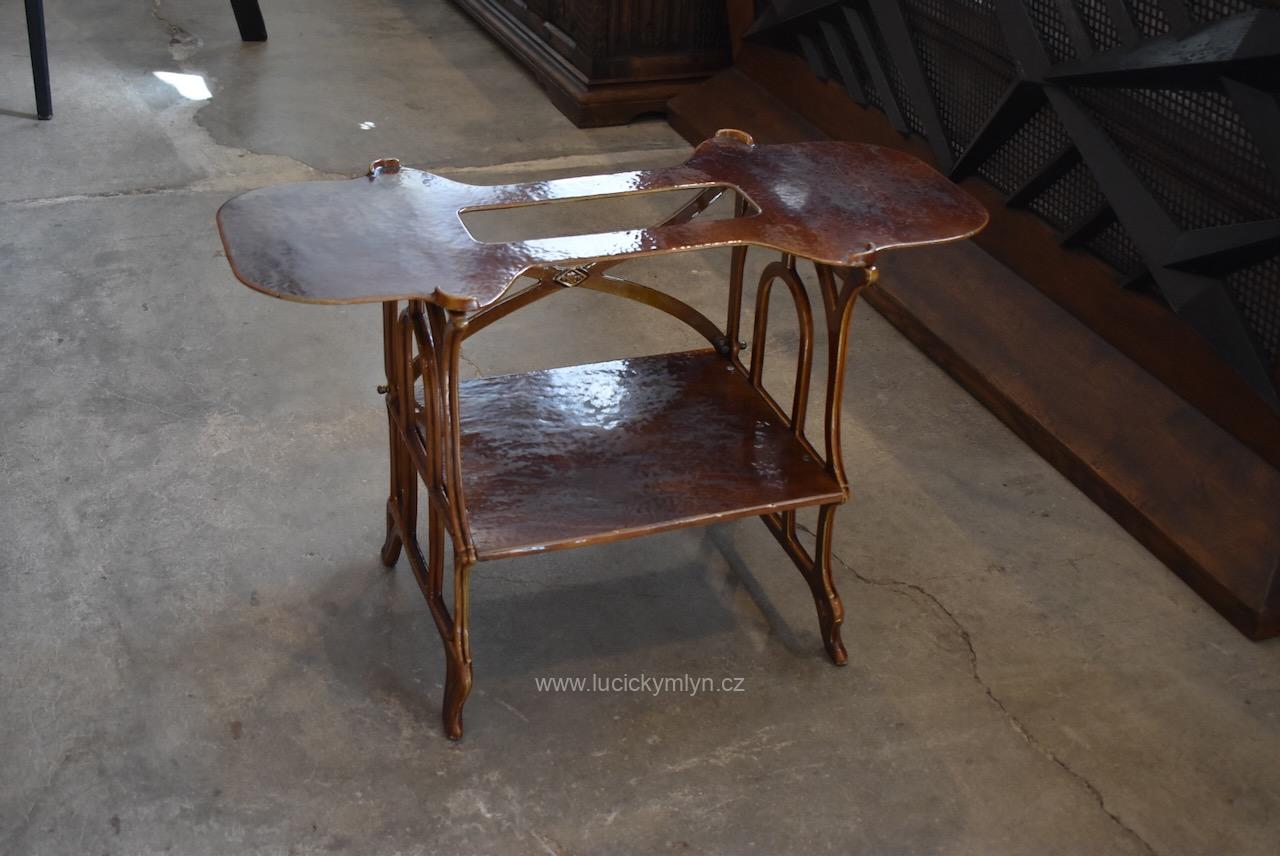 Pevný a praktický starožitný stolek elegantně ztvárněný ve vzdušném secesním stylu ze smaltované litiny - původně účelově dekorativní podstavec pro vařič typu Nestor Martin z počátku 20. století. Starožitný litinový stolek ve vzdušném secesním stylu, původně podstavec pro vařič Nestor Martin.