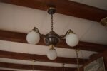 Starožitný prvorepublikový tří-ramenný lustr z patinované mosazi s mléčnými skleněnými koulemi.