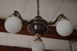 Starožitný prvorepublikový tří-ramenný lustr z patinované mosazi s mléčnými skleněnými koulemi.