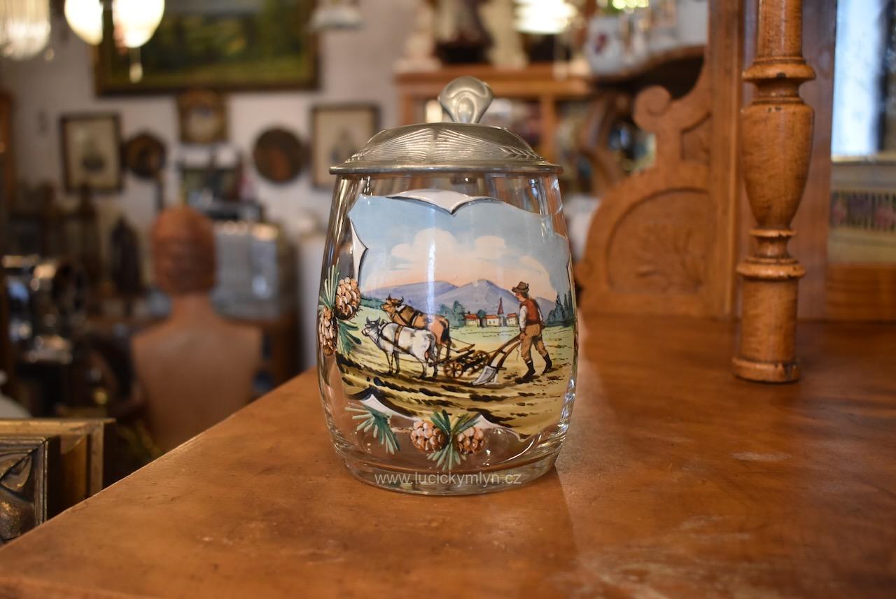 Starožitný dárkový půllitr okrášlený v secesním stylu s nápisem „Josef“ osazený ozdobnou cínovou montáží s reliéfně zdobeným víčkem a malovaným selským motivem Starožitný dárkový půllitr Josef s cínovou montáží a ručně malovaným selským motivem