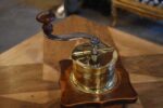 Starožitný biedermeierovský kávomlýnek z ořechového dřeva s mosaznou válcovou násypkou.