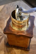 Starožitný biedermeierovský kávomlýnek z ořechového dřeva s mosaznou válcovou násypkou.