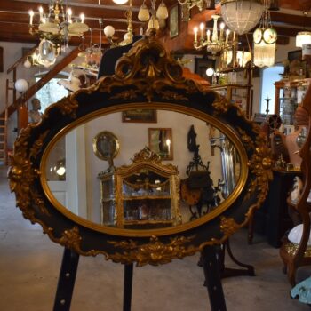 Starožitné oválné nástěnné zrcadlo v černo-zlatém rokokově historizujícím rámu