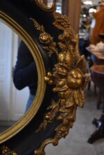 Starožitné oválné nástěnné zrcadlo v černo-zlatém rokokově historizujícím rámu
