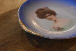 Pár starožitných secesních porcelánových talířů s portréty dam a zlatými uchy.