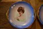 Pár starožitných secesních porcelánových talířů s portréty dam a zlatými uchy.
