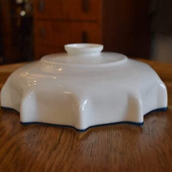 Starožitné mléčně bílé foukané stínidlo na stahovačku se zvlněným okrajem a modrou linkou.