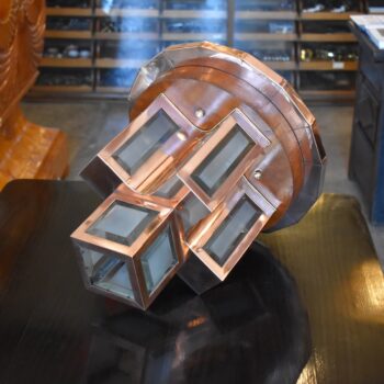 Starožitný modernistický stropní lustr z leštěné mědi a fasetového skla ve tvaru kříže.