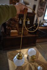 Starožitná párová závěsná světla z mosazi s geometrickými matovými skleněnými koulemi.