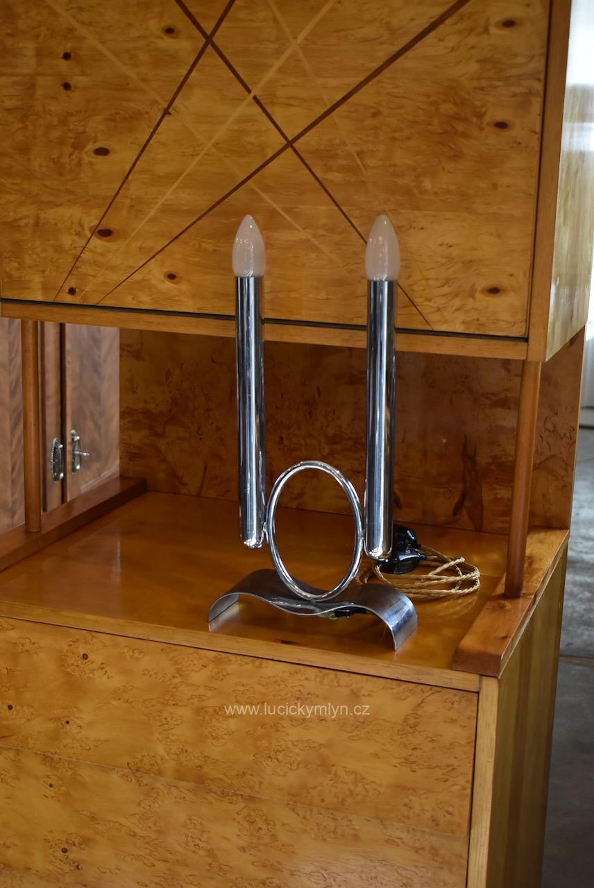 Velmi vkusná starožitná stolní lampička z chromované mosazi se zvlněnou základnou a dvěma světelnými sloupky romanticky navržená ve funkcionalistickém prvorepublikovém stylu (Kopírovat) Starožitná funkcionalistická stolní lampička z chromované mosazi se dvěma svícnovými sloupky