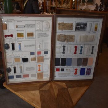 Historické školní vitrínky s výukovými panely ovčí vlny a umělých vláken z období socialismu.