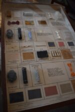 Historické školní vitrínky s výukovými panely ovčí vlny a umělých vláken z období socialismu.