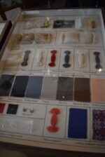 Historické školní vitrínky s výukovými panely ovčí vlny a umělých vláken z období socialismu.