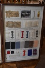 Historické školní vitrínky s výukovými panely ovčí vlny a umělých vláken z období socialismu.