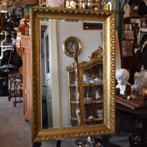 Starožitné nástěnné zrcadlo v zlatém biedermeirovském rámu s listovcem a vejcovcem.