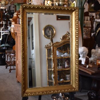 Starožitné nástěnné zrcadlo v zlatém biedermeirovském rámu s listovcem a vejcovcem.